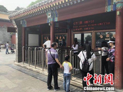 5月10日,北京北海公园门口,一名小女孩正在排队购票。 冷昊阳 摄 点击进入下一页